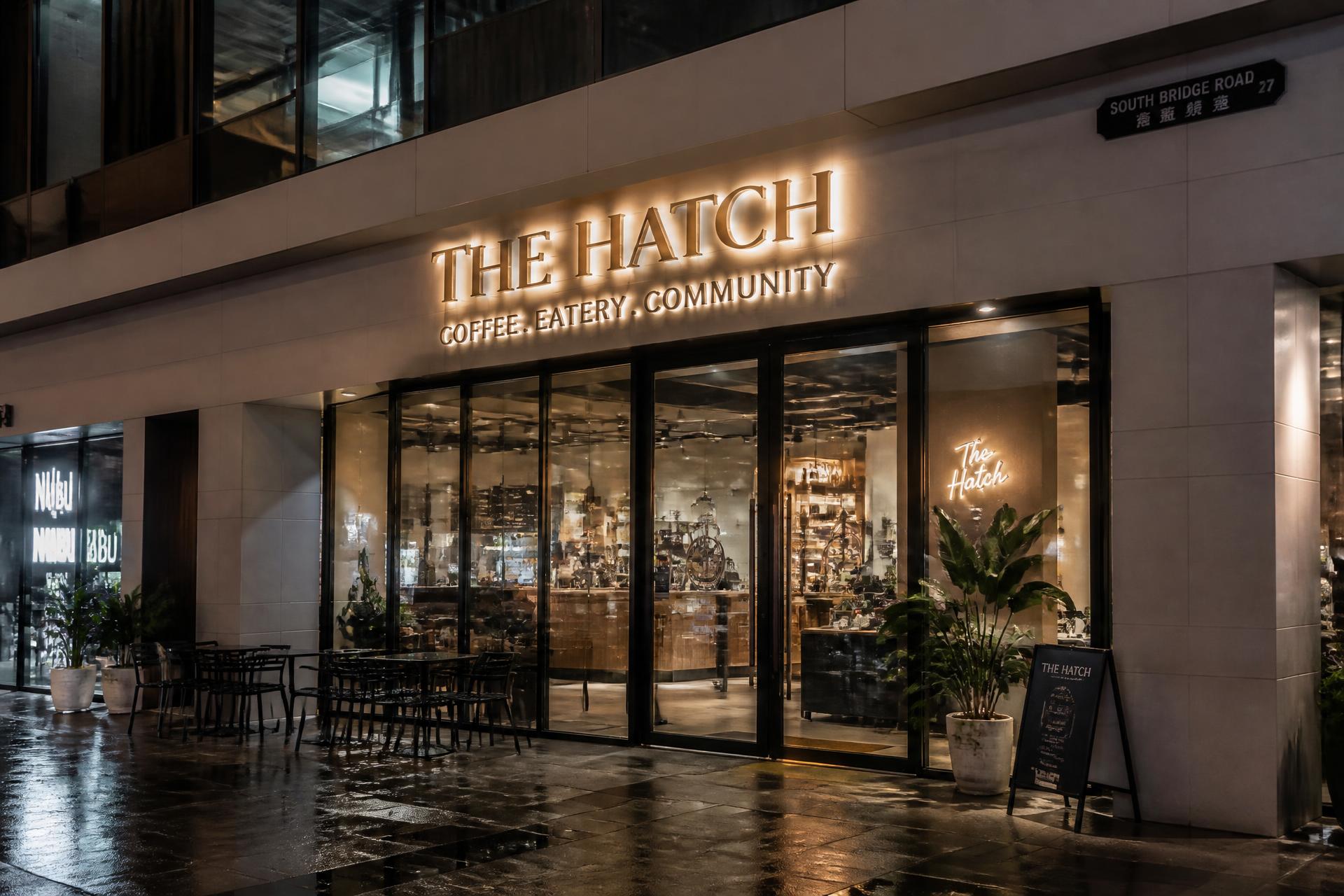 Illuminated 3D channel-letter shopfront sign on a Singapore café at night